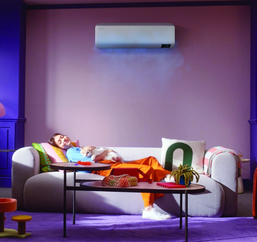 Samsung WindFree high wall heat pump installed above a living room sofa